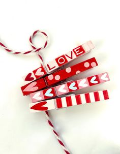 some candy sticks are wrapped in red and white paper with the word love on them