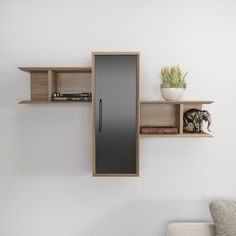 a wall mounted refrigerator sitting next to a shelf filled with books and other items on top of it