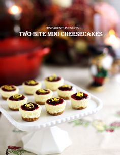 mini cheesecakes are arranged on a cake plate with the words two - bite