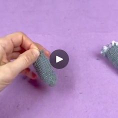 someone is making something out of knitted material on the floor with their fingers and thumbnails