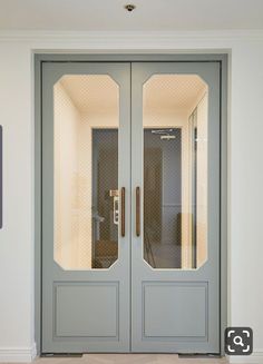 two double doors with glass panels in the center and bottom panel on each side, leading to an elevator