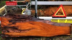 a large piece of wood sitting on top of a wooden floor next to a road sign