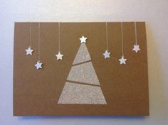 a brown card with white stars hanging from it's sides and a christmas tree in the middle