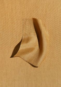 the top half of a piece of cloth is folded up in an angled position on a beige background