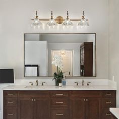 a bathroom vanity with two sinks and a large mirror above it, along with a television on the wall