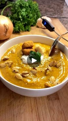 a white bowl filled with soup and garnished with croutons