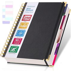 a black notebook with colorful stickers on the front and back cover is open to show what's inside