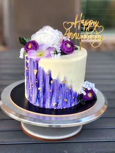 a white and purple cake with flowers on top