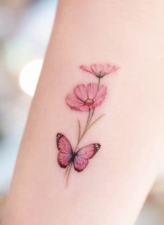 a small pink flower with a butterfly tattoo on the left side of the arm,