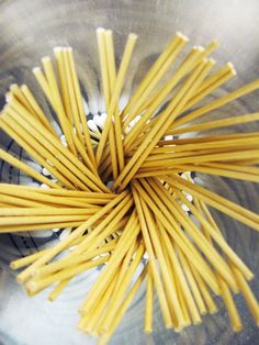 some yellow noodles are in a glass bowl