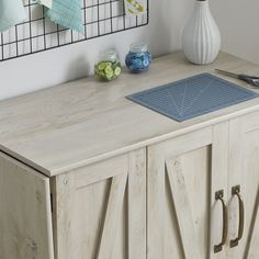 a wooden cabinet with scissors and other items on the counter top in front of it