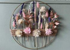 a metal circle with flowers on it hanging from the wall next to a blue wall