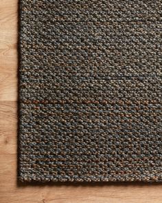 a brown and black area rug on top of a wooden floor next to a phone