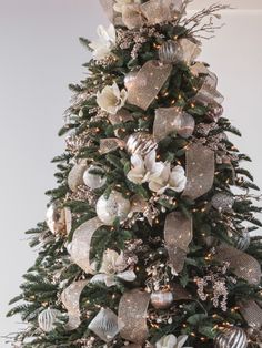 a decorated christmas tree with silver and white ornaments