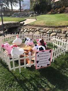 some stuffed animals are sitting in a fenced area