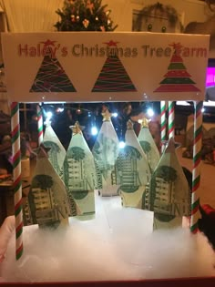 christmas tree farm made out of money and candy canes on display in front of a christmas tree