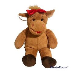 a brown stuffed cow with a red bow on its head