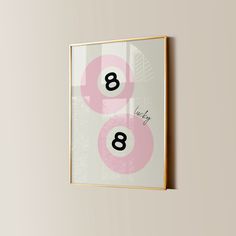 a pink and white poster hanging on the wall next to a wooden frame with numbers