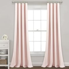 the pink curtains are hanging in front of a window with white walls and wooden floors