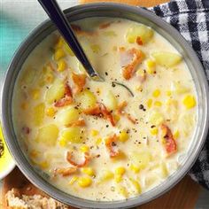 there is a bowl of soup with bread on the side and a spoon in it