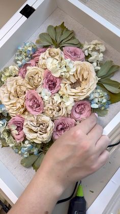 a person using scissors to cut flowers in a box