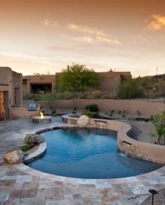 an outdoor swimming pool surrounded by landscaping