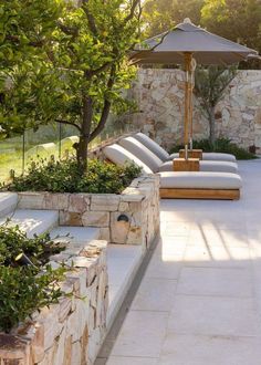 an outdoor patio with lounge chairs and umbrella