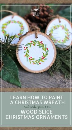 three wooden ornaments with holly and berries on them, sitting next to pinecone cones