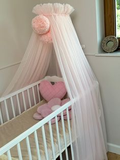 a white crib with a pink teddy bear in it