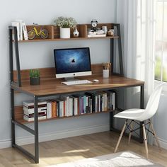 a desk with a computer and bookshelf next to a window in a room