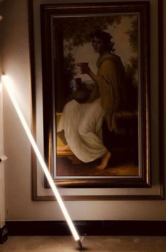 a light saber is lit up in front of a painting