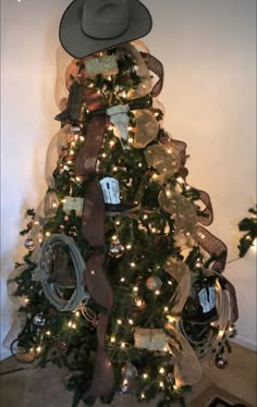 a christmas tree decorated with ribbons and hats