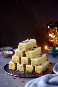 several pieces of cake stacked on top of each other in front of a lit candle