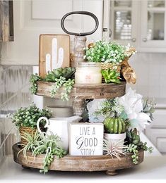 a three tiered tray with succulents and plants on it in a kitchen