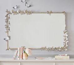 a white dresser topped with lots of drawers and a large mirror over top of it