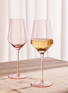 two wine glasses sitting on top of a table