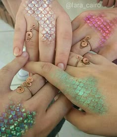 several people are holding their hands together with different designs on them