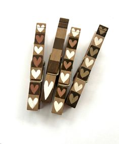 four pieces of wood with hearts painted on them sitting next to each other in front of a white background