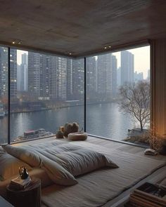 a large bed sitting in front of a window next to a tall building with lots of windows