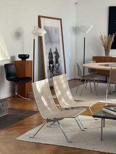 a living room filled with furniture and a painting on the wall