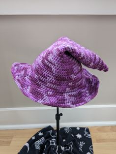 A handmade crochet witch hat made with purple mottled acrylic yarn. Made to be slouchy and comfy, with a moldable wire brim. Cozy muted purples ranging from lavender to deep eggplant.  Hat has a 11" diameter straight across the brim at the widest point. The inside circumference is roughly 20-22" - it can stretch a bit. Pattern: TheEntangledFae - https://www.etsy.com/shop/TheEntangledFae Handmade Purple Cap, Hand Knitted Purple Yarn Hats, Handmade Purple Hat One Size, Adjustable Hand Knitted Purple Crochet Hat, Adjustable Hand-knitted Purple Crochet Hat, Adjustable Purple Crochet Yarn Hat, Adjustable Purple Yarn Crochet Hat, Purple Adjustable Crochet Hat, Adjustable Purple Crochet Hat