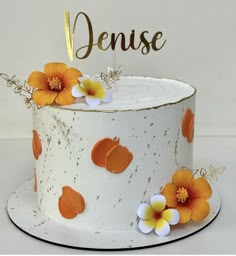 a close up of a cake with flowers on it and a name sign in the middle