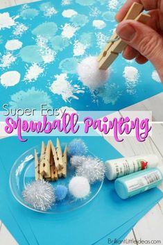 someone is making snowball painting with popsicle sticks and glue on the paper plate