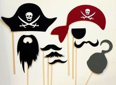 pirate photo booth props with mustaches, hats and eyeballs on sticks in front of a white background