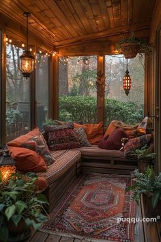 a screened porch with lots of plants and lights