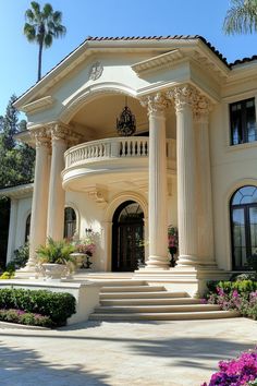 a large white house with columns and flowers