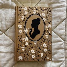 a book with a silhouette of a woman on it sitting on top of a bed