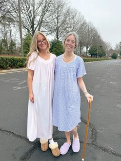 two women standing next to each other in a parking lot