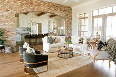 a living room filled with furniture and a brick wall