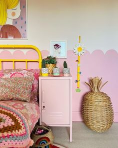 a bedroom with pink walls and a yellow metal bed frame in front of a painting on the wall